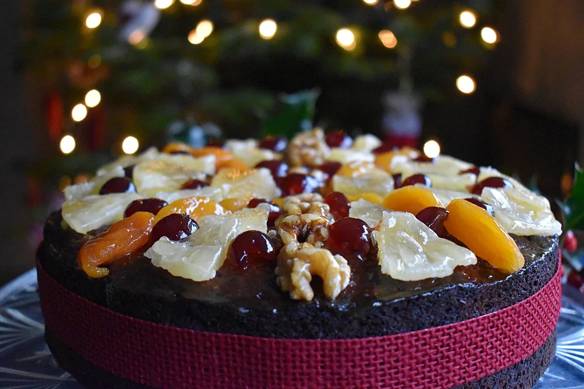 Boiled Fruit Cake for Christmas with lights of a Christmas tree in the background.